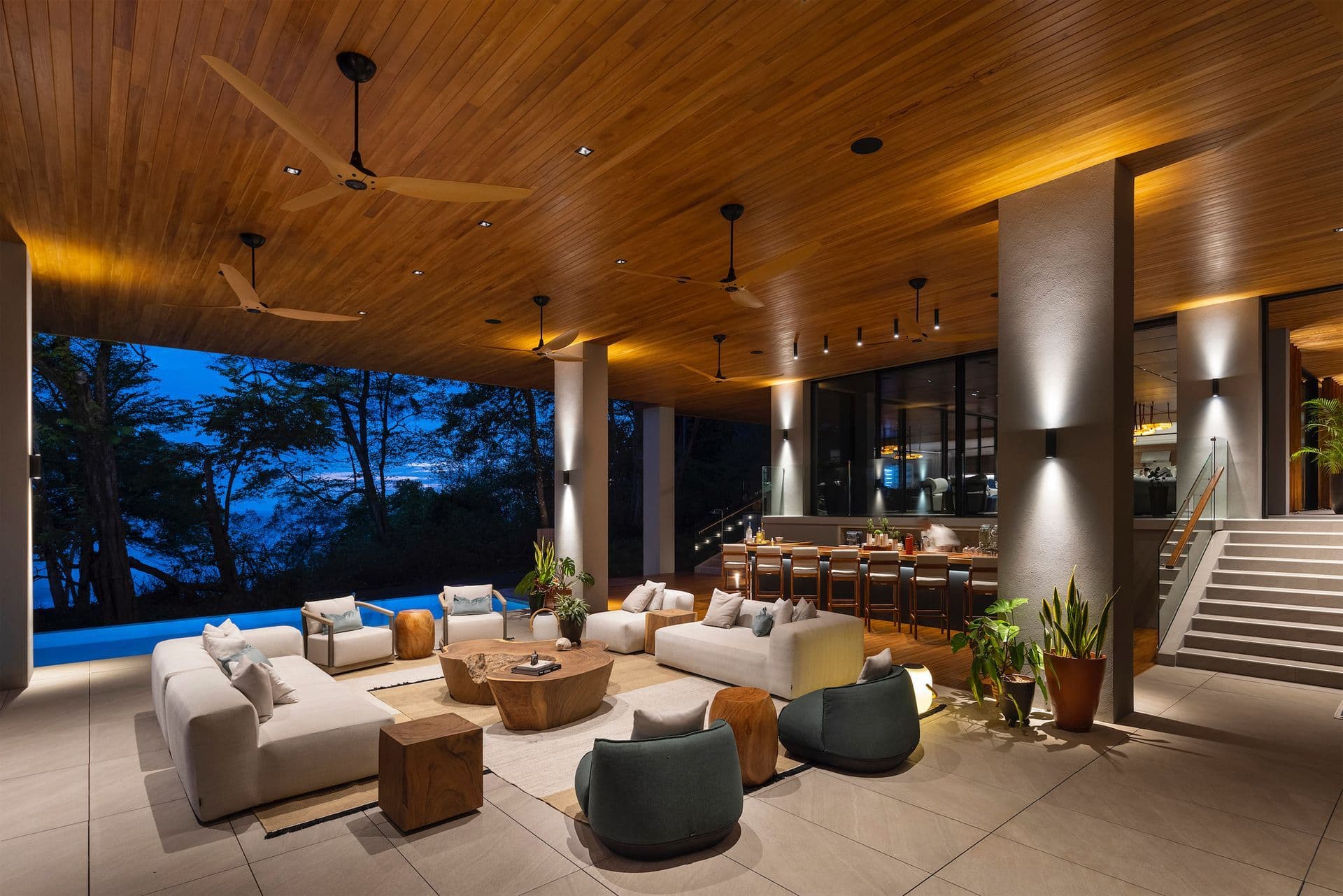 Warm evening light fills the lounge as blue hour arrives beyond the pavilion.